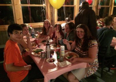 table of young people smiling at the camera while enjoying the best seafood from Moby Dick's with balloons hanging