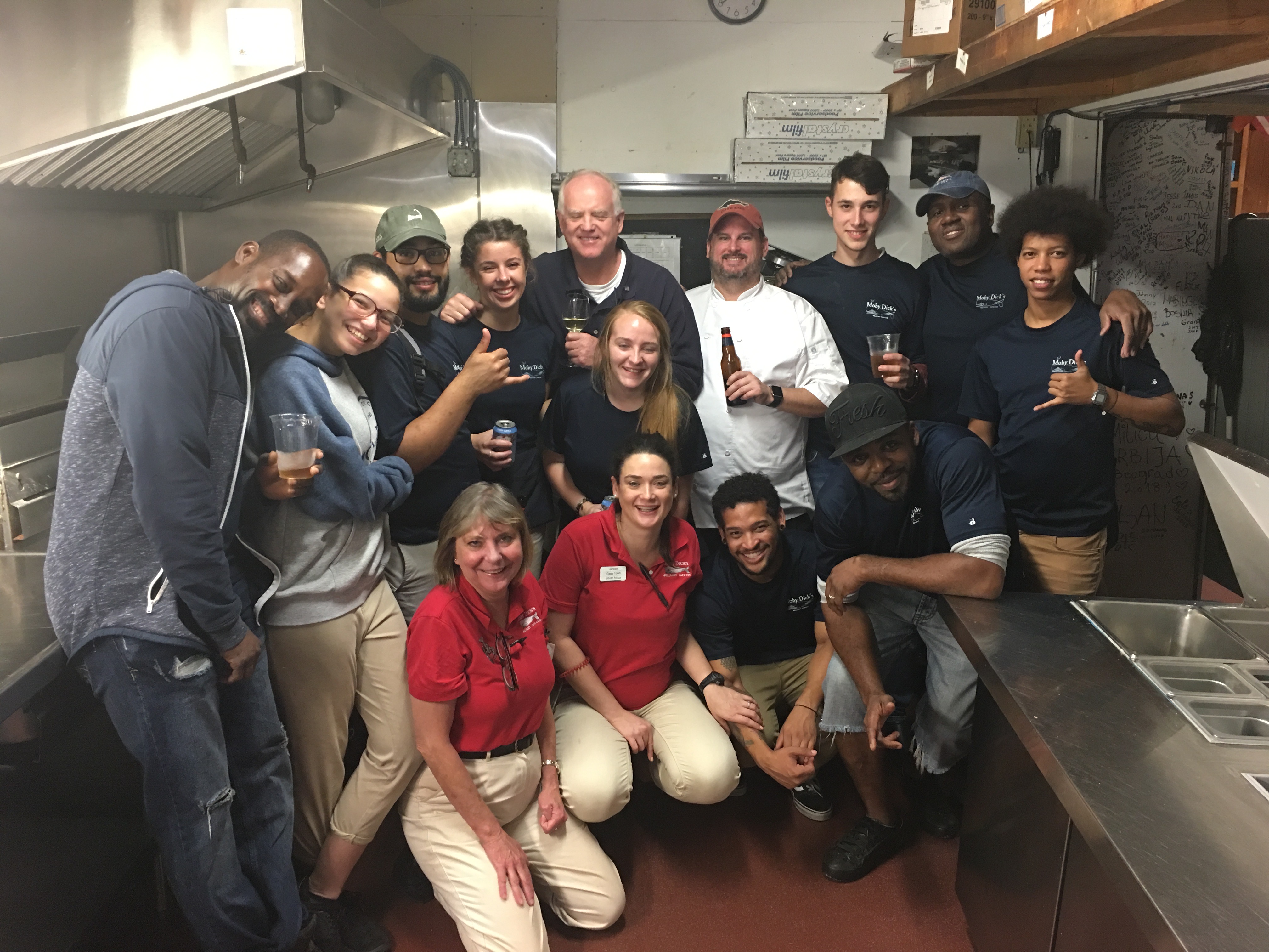 group photo of Moby Dick's restaurant staff in the kitchen holding drinks