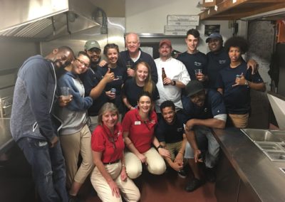 group photo of Moby Dick's restaurant staff in the kitchen holding drinks